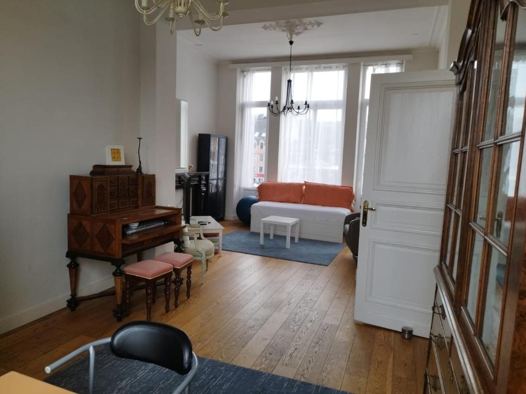 - un salon avec un canapé et un piano dans l'établissement Antique appartement au centre d'Andenne, à Andenne