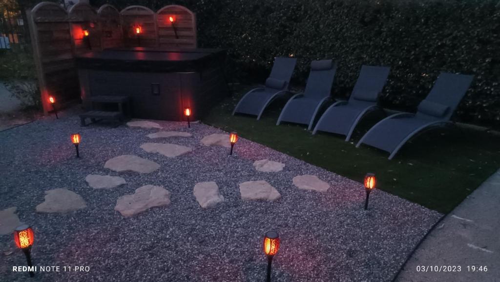 La Remise de Guytou et Spa في شيفال - بلانك: مجموعة من الكراسي والشموع على الأرض مع وجود أضواء