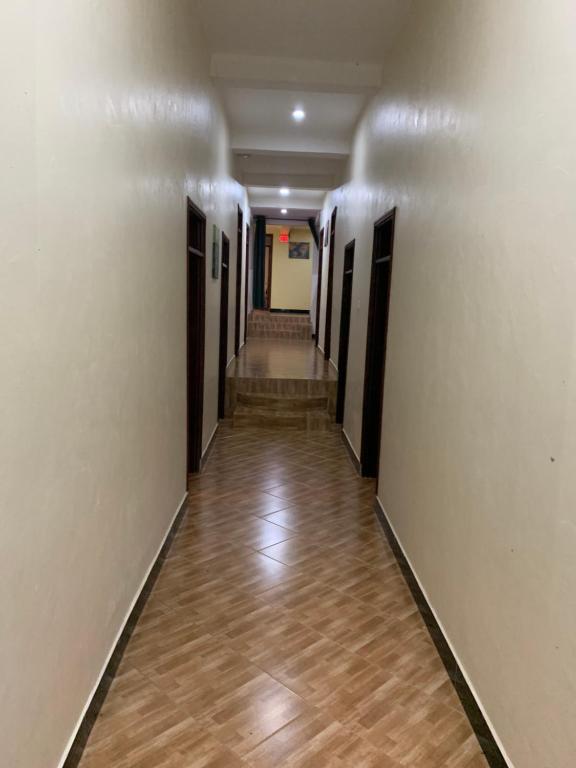 a hallway with a long corridor with wooden floors at Mpanga Nature Center in Mpigi