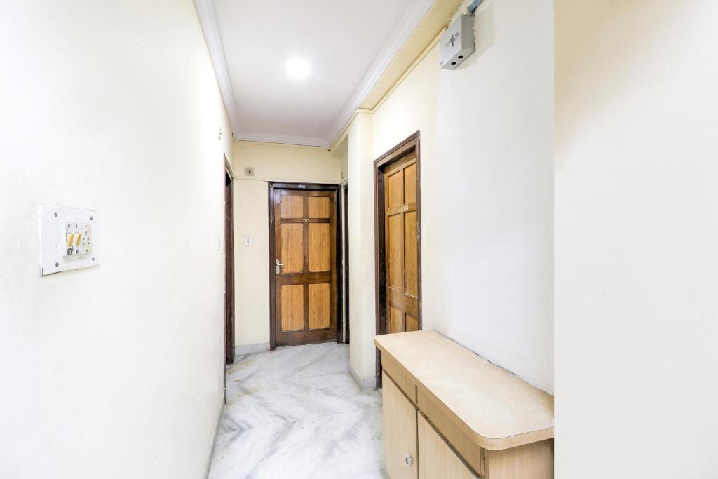 um corredor com paredes brancas e portas de madeira em SPOT ON Hotel Sanskriti em Nagpur