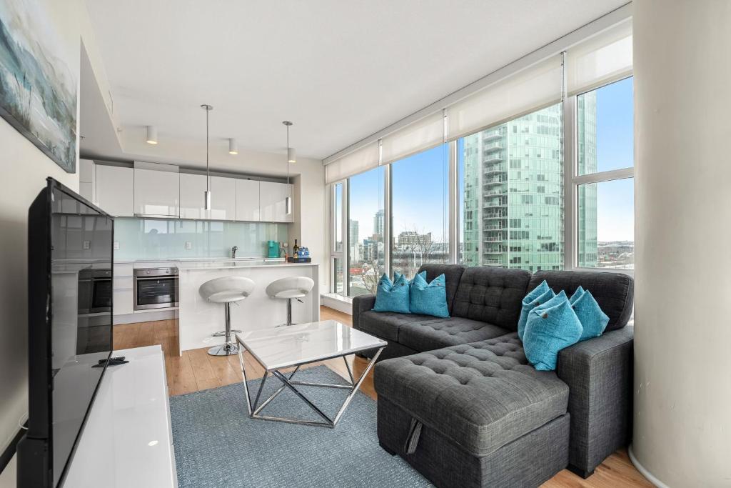 a living room with a couch and a table at Walk to Bars, Casino, Stampede & Saddledome PLUS FREE Bonus Banff Pass, Parking & Wine! in Calgary