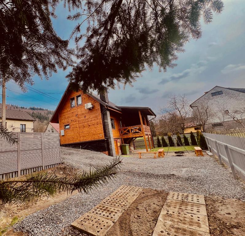 una cabaña de madera con una valla delante en Domek RajskiRaj en Rajcza