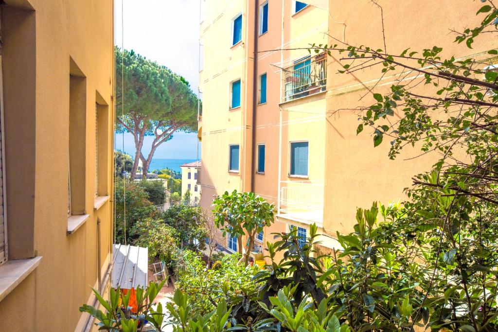 een steegje tussen twee gebouwen met bomen en de oceaan bij La Casetta al Mare by PortofinoVacanze in Rapallo