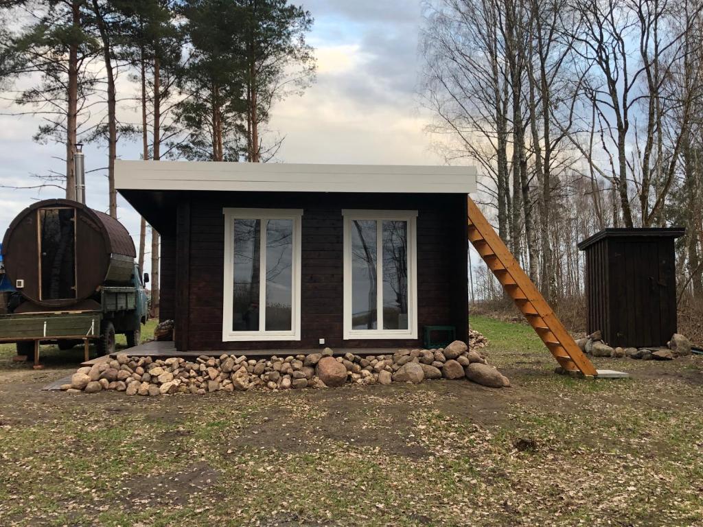 a small tiny house with a ramp next to a truck at Saare-Toominga camping house in Väike-Rakke