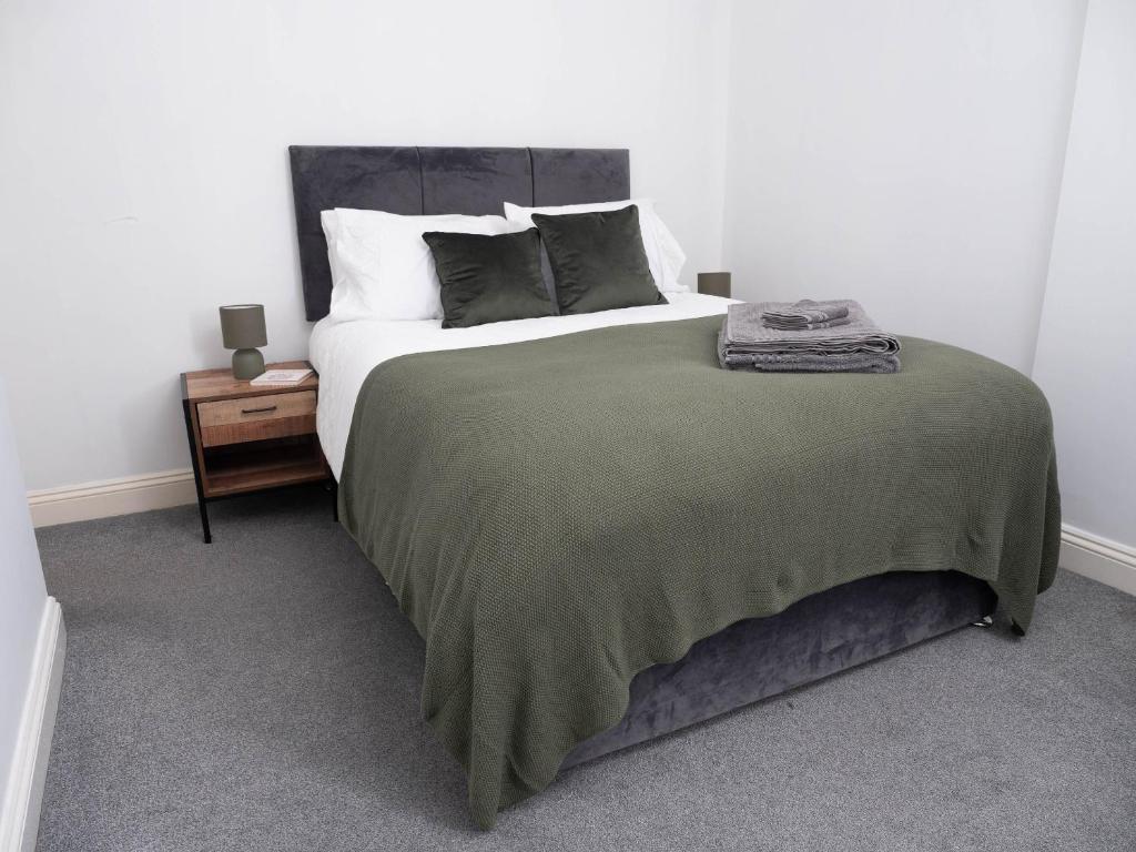 a bedroom with a large bed with a green blanket at Apartment in Brighton in Brighton & Hove