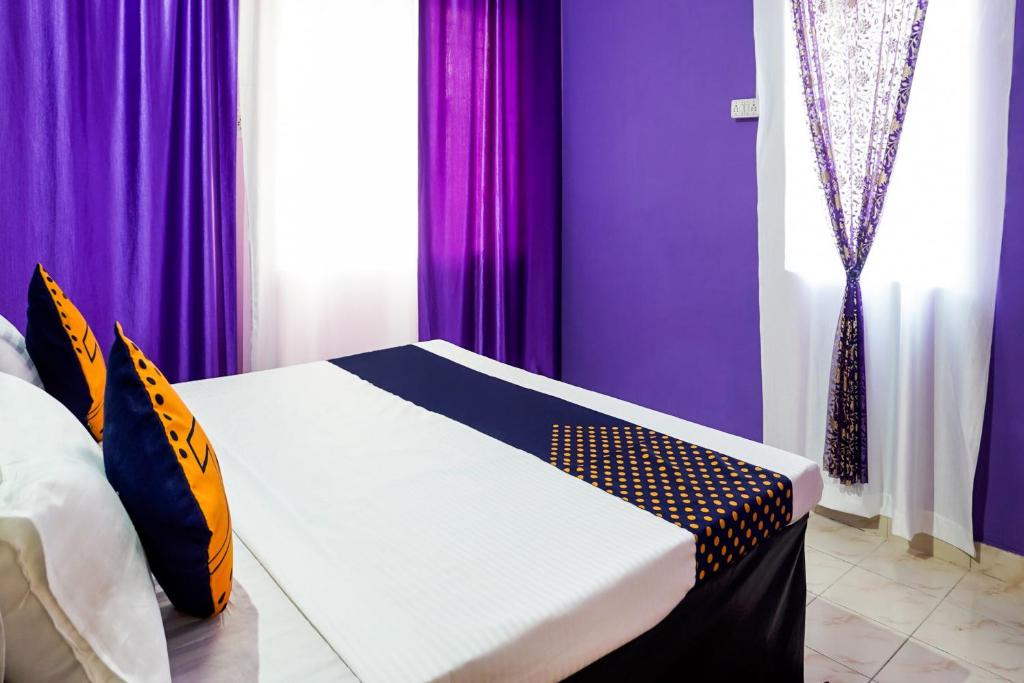 a bedroom with purple curtains and a bed in it at SPOT ON Krrish 2 in Durg