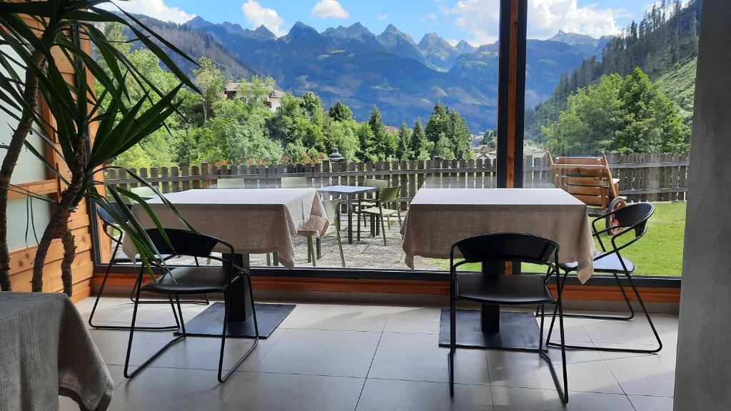 um quarto com mesas e cadeiras e uma grande janela em B&B B&Beautyfol Dolomites adults only em Predazzo