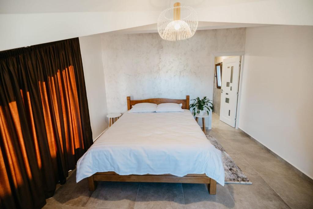 EDANT HOUSE في Bumbesti Pitic: غرفة نوم بسرير كبير وثريا