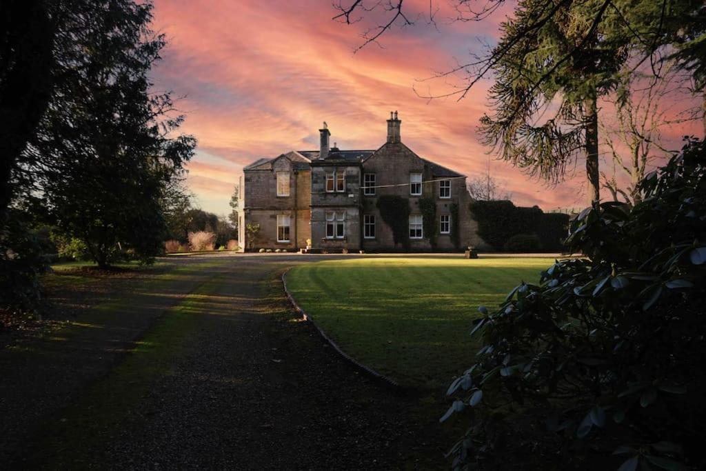 a large house with a sunset in the background at Edenfield House, Springfield, Fife in Cupar