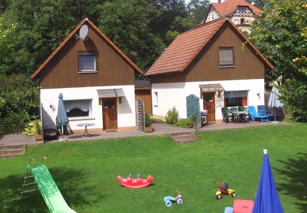 ein Haus mit einem Hof mit Spielzeug davor in der Unterkunft Kinderfreundliches Ferienhaus mit großer Spielwiese. in Marktgraitz