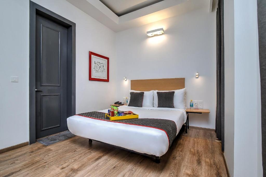 a hotel room with a large bed and a desk at OYO Townhouse 607 Paschim Vihar in New Delhi