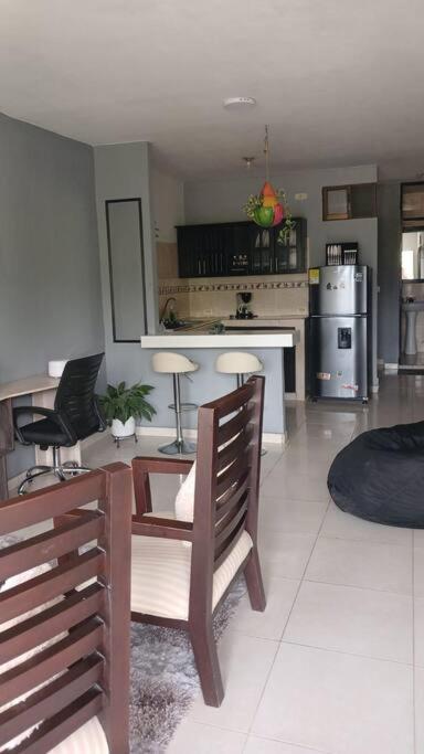 Una sala de estar con mesa y sillas y una cocina. en Apto 3 alcobas, Segundo piso Norte de Cali, en Cali
