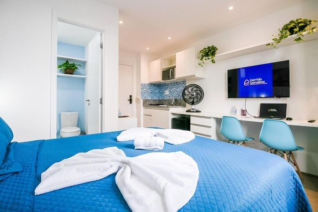 1 dormitorio con 1 cama azul y 2 sillas azules en Santorini Studio no Brás com Piscina/Metrô Brás, en São Paulo