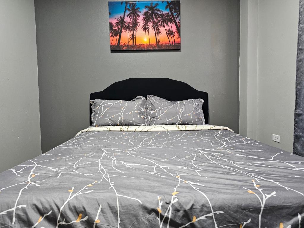 1 dormitorio con 1 cama con una foto en la pared en In-flight Suites - Perfect for Layovers 6Mins from the Airport en Piarco