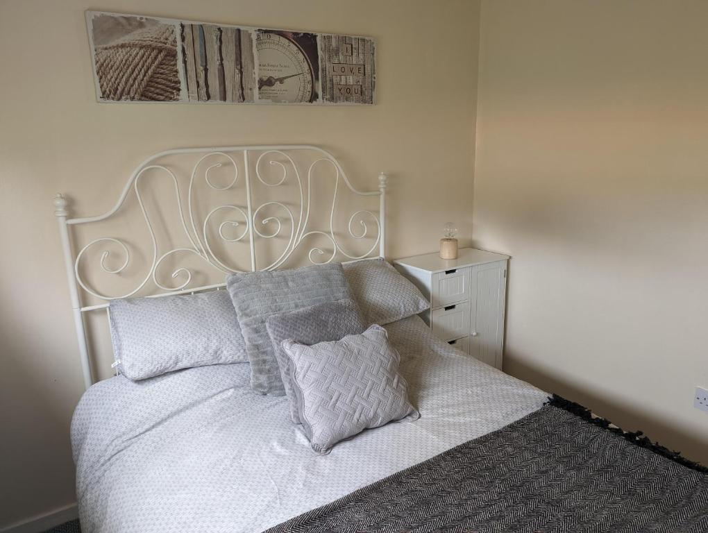 a bedroom with a white bed with two pillows at Hemsby Holiday Home - Norfolk beach & seaside fun in Great Yarmouth