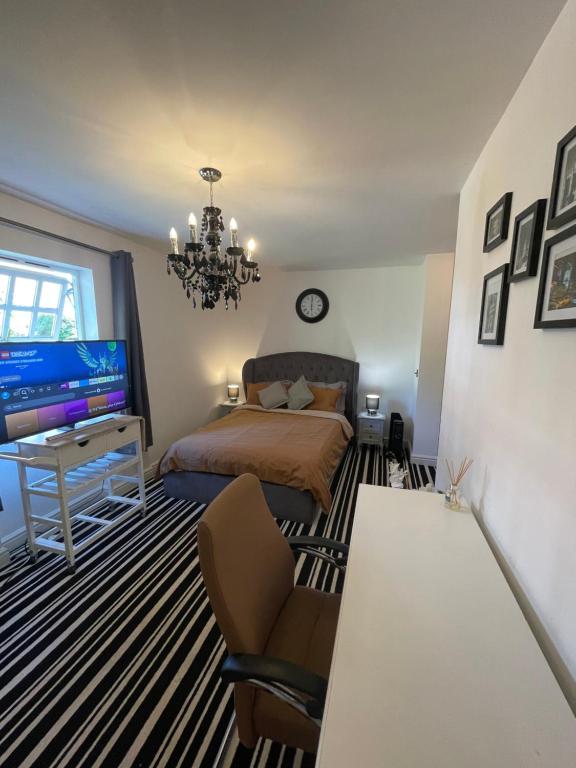 a bedroom with a bed and a tv and a chair at 1 Bed Apartment Oxford - Fits 4 Guests in Oxford