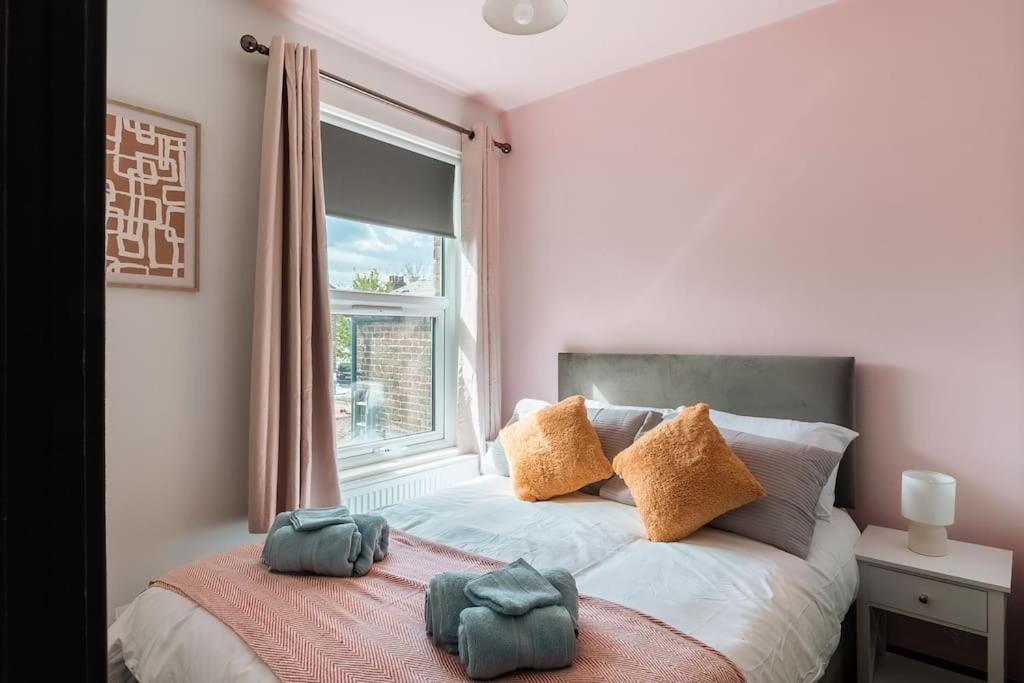 - une chambre avec un lit doté d'oreillers et d'une fenêtre dans l'établissement EDMONTON - 4 bedrooms, Sleeps 8, 3 bathroom Contractor Base, à Londres