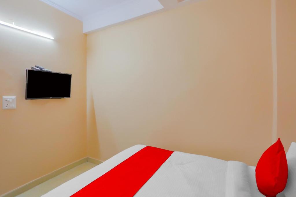 加濟阿巴德的住宿－Flagship The Siddhartha，卧室配有一张床,墙上配有电视。