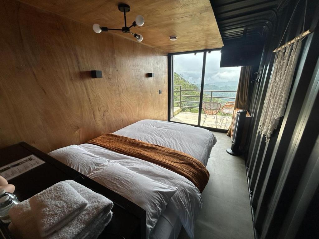 sypialnia z 2 łóżkami i dużym oknem w obiekcie Nomada Republic Hotel El valle w mieście Antón