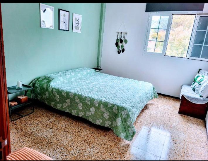 1 dormitorio con 1 cama y 1 silla en Casa del aire libre, en Moya