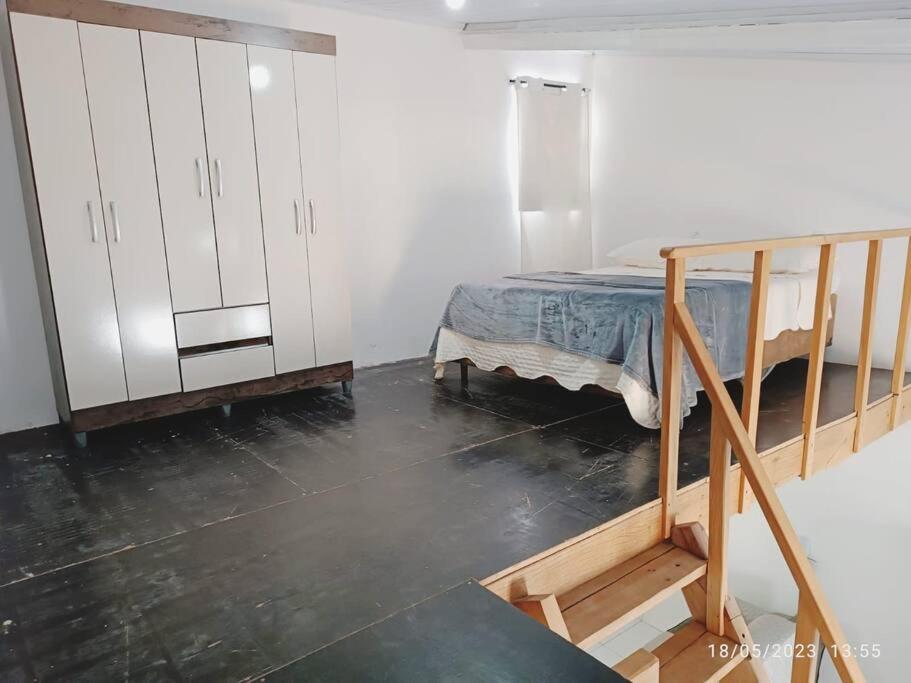 a bedroom with a bed and a white cabinet at Apartamento Loft 03 Ponta Porã MS. in Ponta Porã