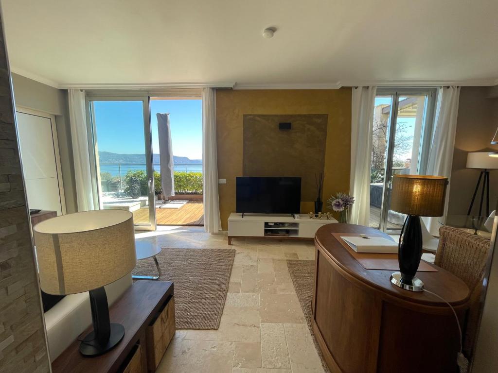 a living room with a couch and a television at Deluxe Sunrise Sky Terrasse 2 Bedroom Design Apartment & Fantastic Lake View in Maderno