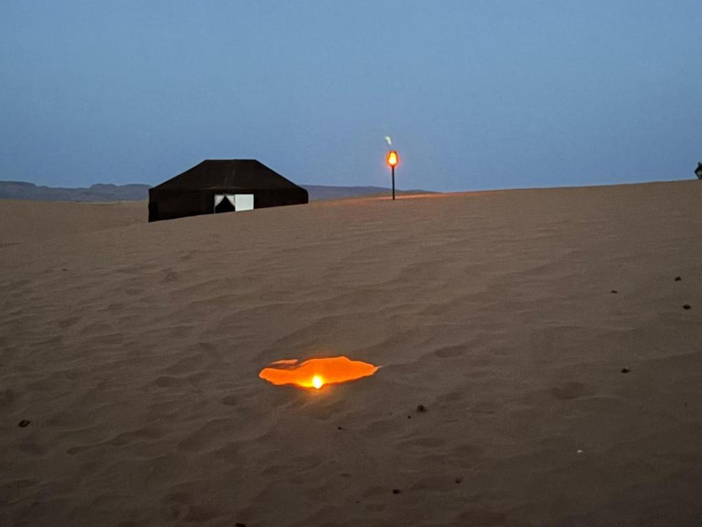 a light in the sand in the desert at Authentique berber Camp in Mhamid