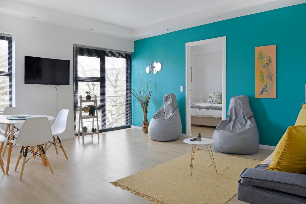 una sala de estar con paredes azules y muebles blancos. en 108 Waverley, en Ciudad del Cabo