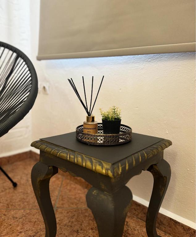 a black table with potted plants on top of it at O Mylos in Ermoupoli