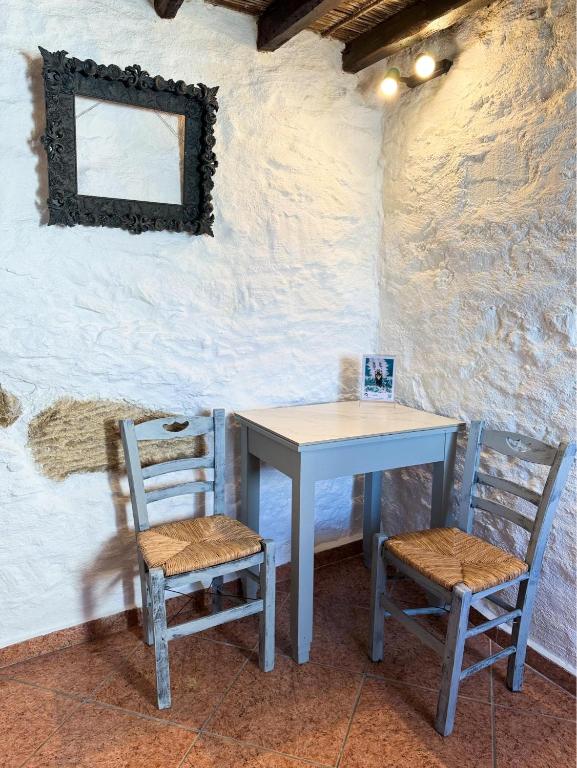 a table and two chairs sitting next to a wall at O Mylos in Ermoupoli
