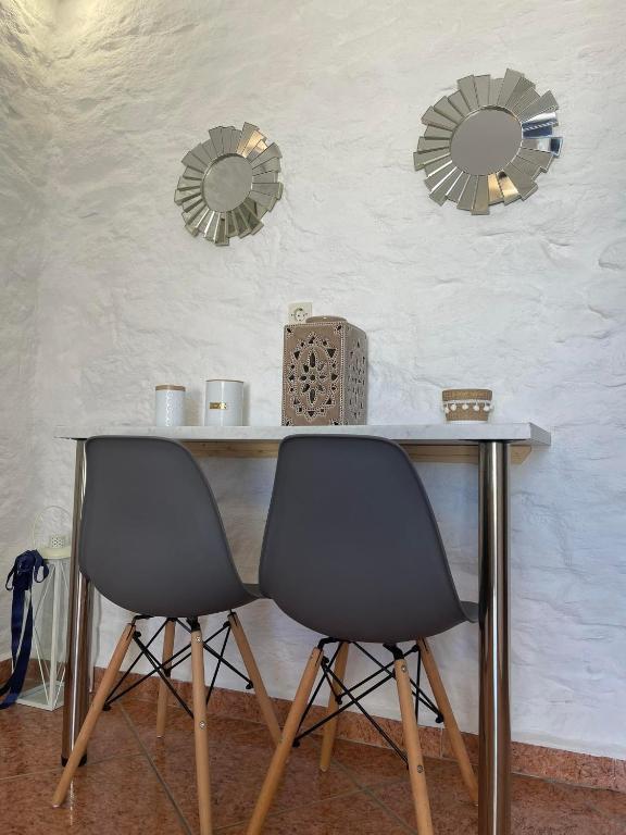two mirrors above a table with two chairs at O Mylos in Ermoupoli