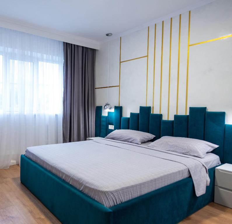 a bedroom with a large blue bed with white sheets at Poetic Apartment Vaslui in Vaslui
