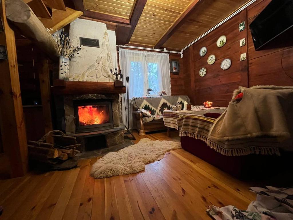 een woonkamer met een open haard, een bank en een tafel bij Domek Nowy Lubiel in Lubiel Stary