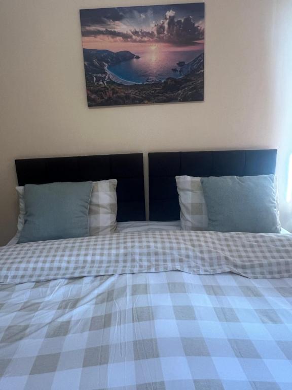Cama con manta y almohadas a cuadros en Room in Essex en Pitsea