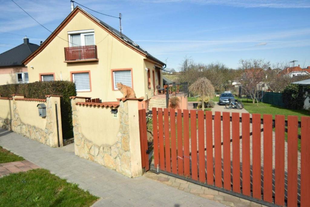 una cerca roja frente a una casa en Marco Art Vendégház for 1- 8 persons, 