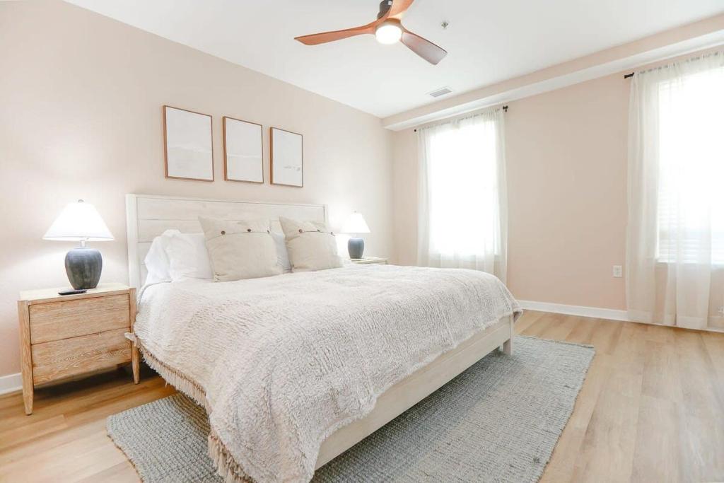 a white bedroom with a bed and a ceiling fan at Sojourn Sanctuary Seaside Escape 3 BR in Virginia Beach