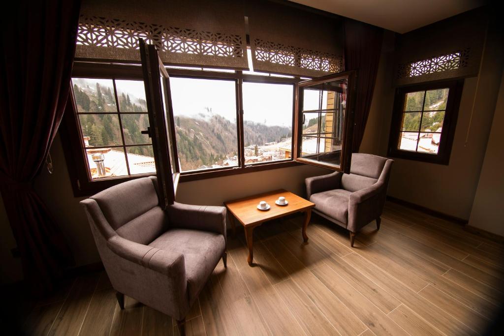 愛迪爾亞伊納斯的住宿－Kervansaray Deluxe Hotel，客厅配有两把椅子和一张桌子,窗户