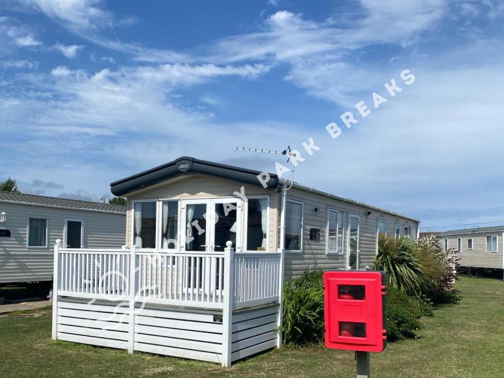 a small house with a red mailbox in front of it at Modern 3 bed; West Sands @ Seal Bay Resort in Chichester