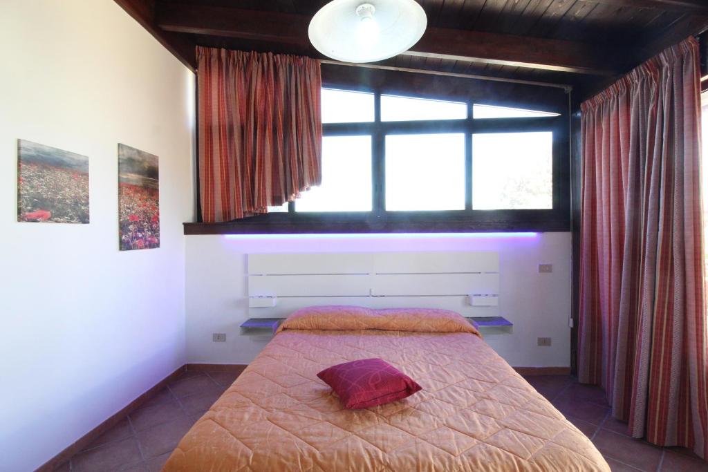 a bedroom with a bed with a large window at Villa Andrea "Vivi l'Oasi di Tranquillità" in Trapani