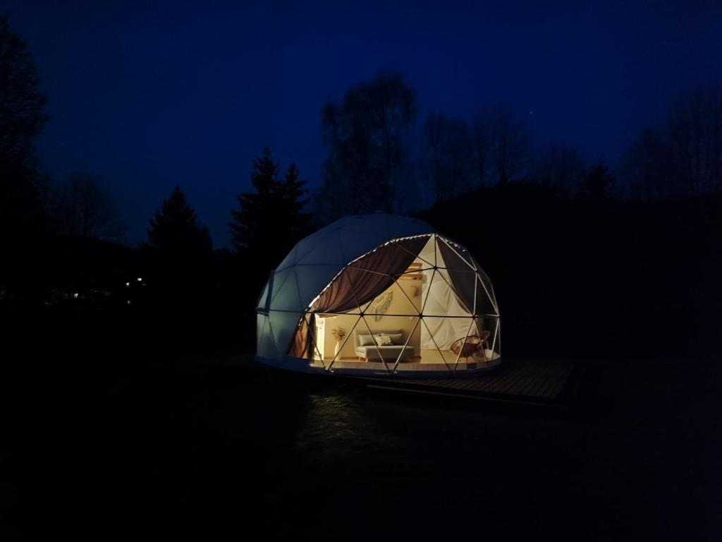 a dome tent is lit up at night at Forrest Glamp in Mieroszów