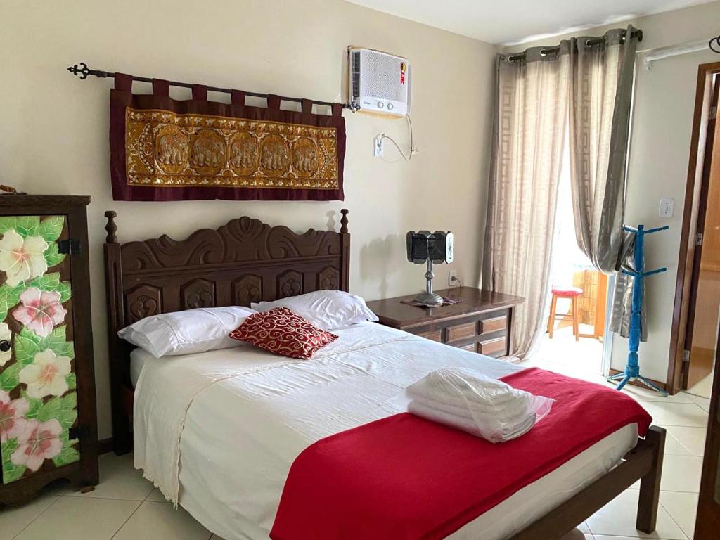 une chambre avec un grand lit recouvert d'une couverture rouge dans l'établissement Beachfront apartment, à Vila Velha