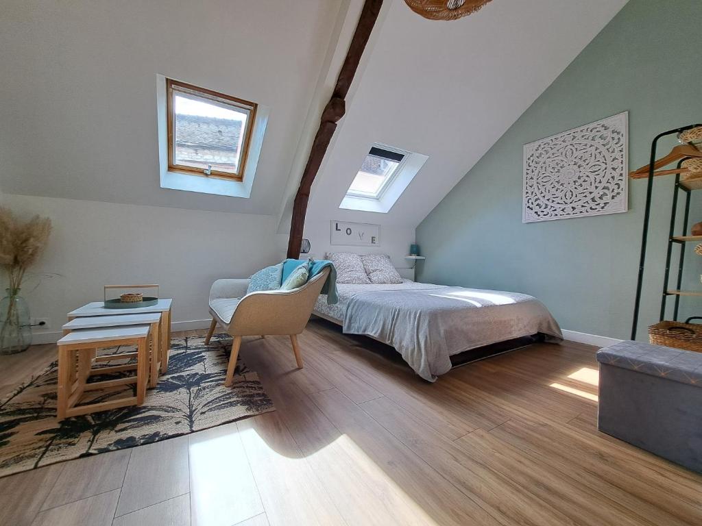 1 dormitorio con 1 cama, 1 mesa y 1 silla en L'Echappée Morétaine - Cœur de Moret, en Moret-sur-Loing