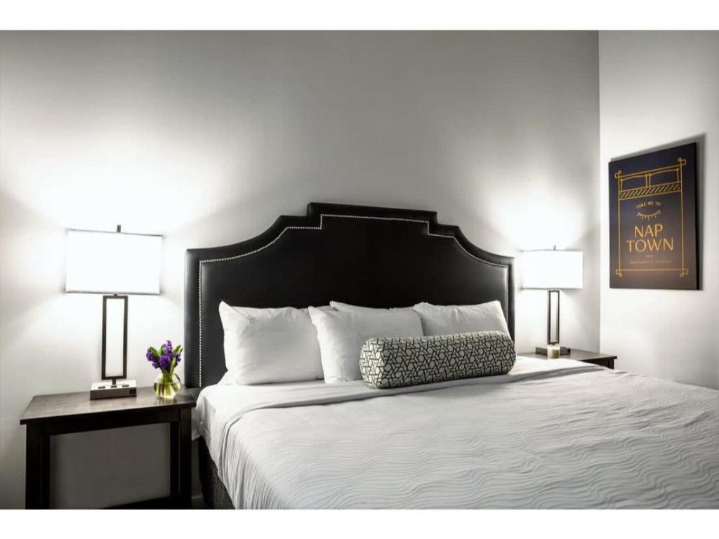 a bedroom with a large bed with two lamps at BOLD 2BR 2BA In The Block Apartment by CozySuites! in Indianapolis