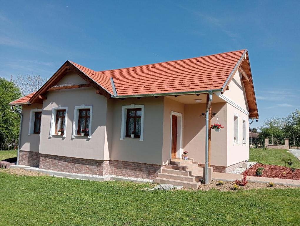 una pequeña casa con techo rojo en Vidéki-Báj Vendégház, en Szentgyörgyvölgy