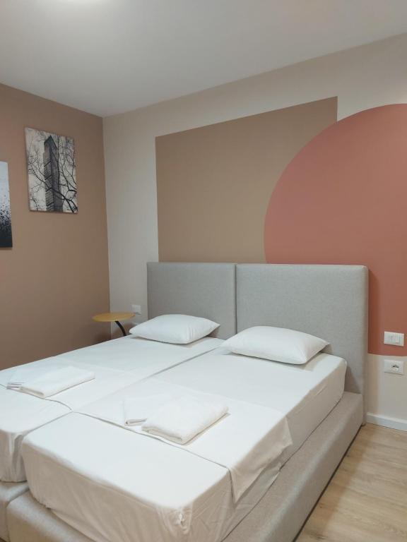 een slaapkamer met een groot bed met witte lakens bij Center Cozy Nest in Tirana