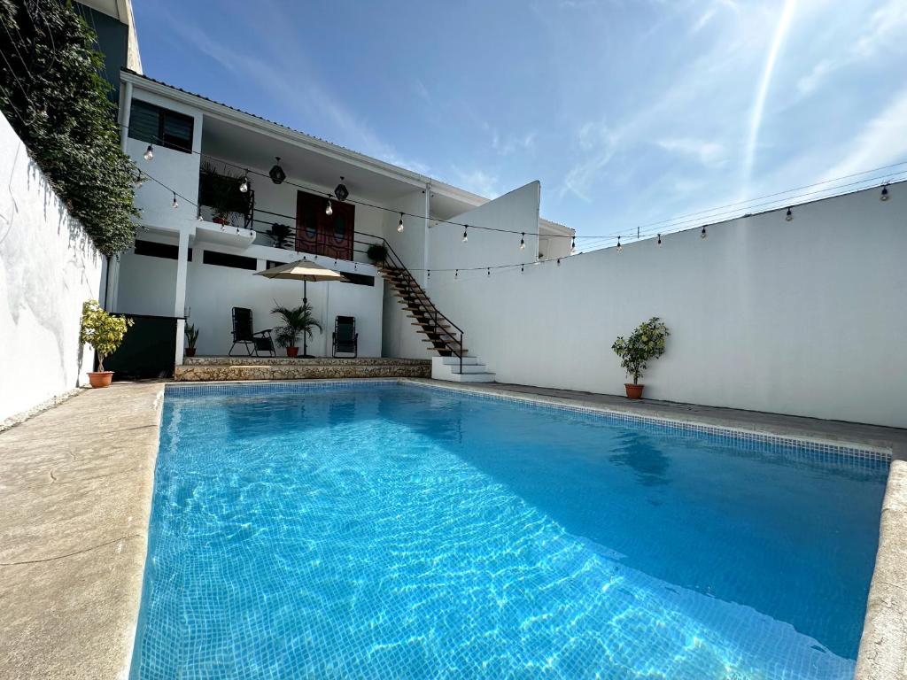 una gran piscina azul junto a un edificio blanco en Beachfront w/ pool & rancho - Casa Coral, en Puntarenas