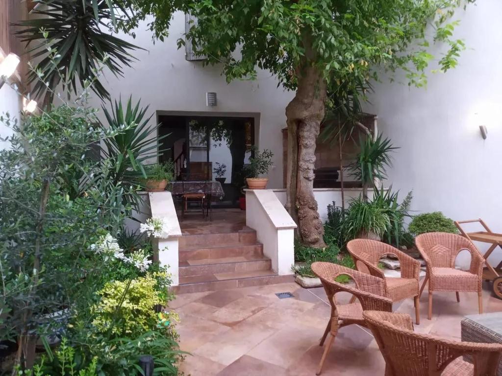 een binnenplaats met tafels en stoelen en een boom bij Maison de 4 chambres avec jardin clos et wifi a Courthezon in Courthézon