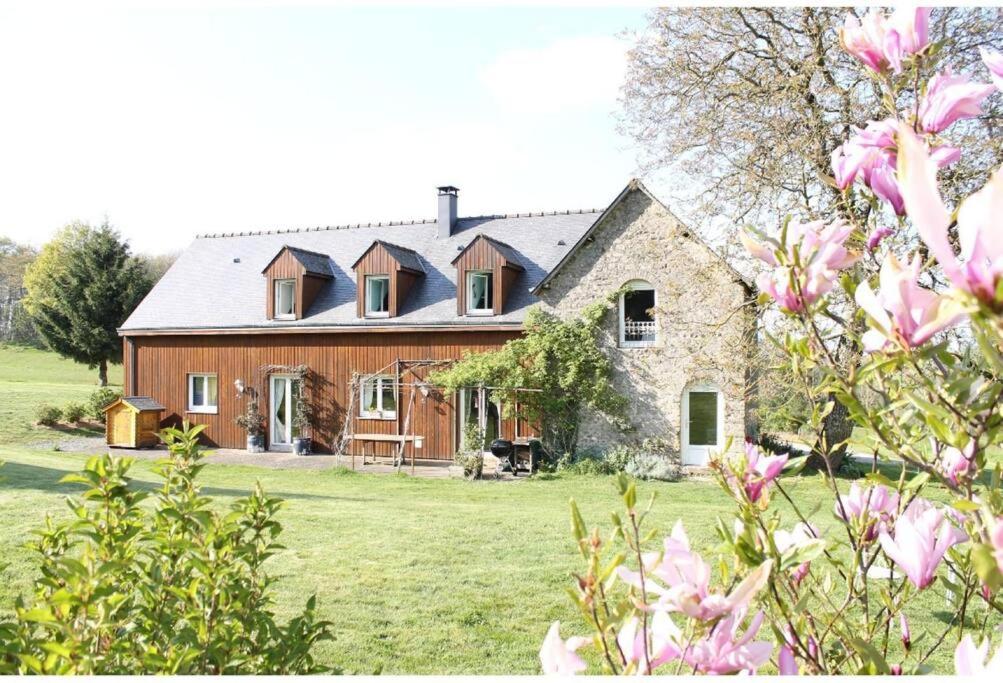 una casa grande en un campo con flores rosas en Maison familiale, 15 pers, 7 chambres, piscine, déco soignée, en Bais