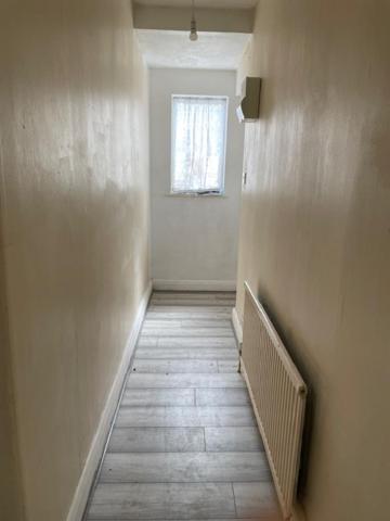 a room with a hallway with a window and a tile floor at Dudley court, Lower Road in Harrow on the Hill