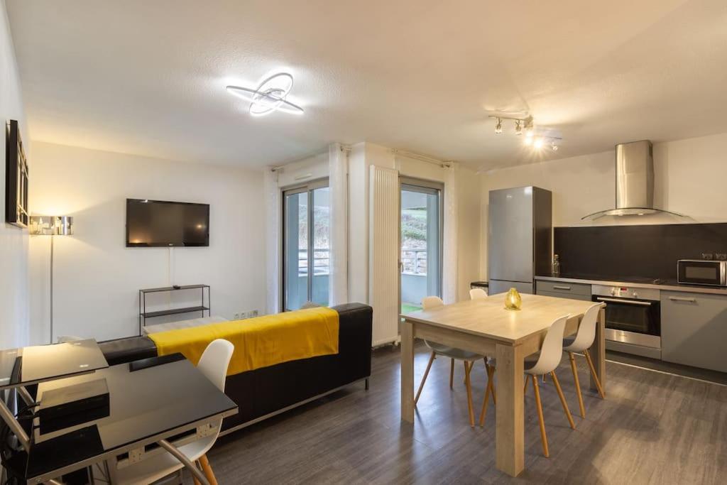 un salon avec un canapé jaune et une table dans l'établissement Chez Jo, Magnifique appartement T2 à Rodez, à Rodez